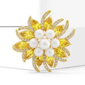 Macro view of a sunflower brooch with yellow zircon petals and a white pearl center