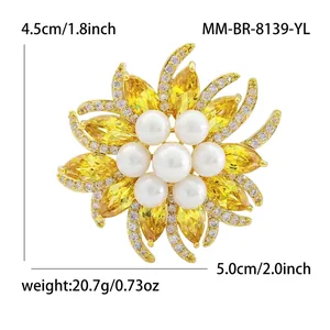 Elegant sunflower brooch with yellow marquise zircons and white pearls in gold-tone.