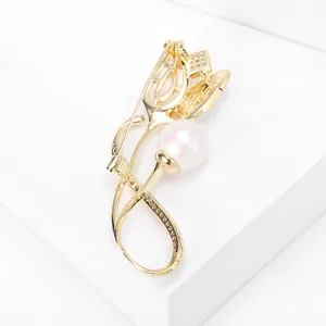 Detailansicht einer eleganten goldenen Tulpenbrosche mit weißer Perle und Strass