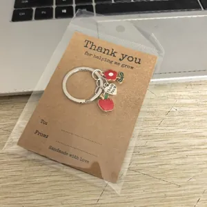 Gros plan détaillé d'un porte-clés pomme et fleur sur un support cartonné brun