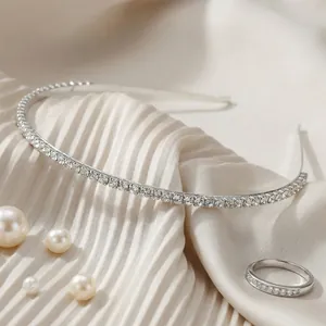 Elegant silver rhinestone headband and matching crystal ring on pleated silk fabric with pearls