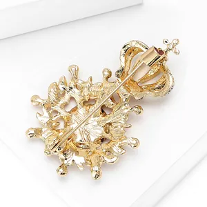 Detailed back view of a gold alloy crown brooch showing textured metal and safety pin clasp