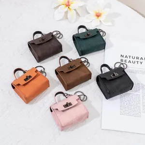 Makroansicht von Miniatur-Handtaschen-Geldbörsen und Schlüsselanhängern in Farben