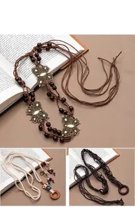 Macro view of hand-woven bohemian waist rope with vintage butterfly charms and wood beads