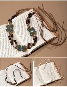 Detailed view of Bohemian hand-woven fringe belts with wooden beads and butterfly motifs.