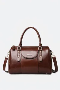 Professional detail view of retro brown oil leather Boston bag with polished gold-tone hardware