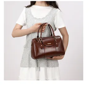 Elegant retro brown oil skin Boston pillow handbag held by model for lifestyle detail