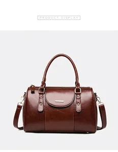 Close-up detail of a vintage brown oil leather Boston bag with elegant gold hardware
