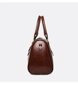 Side view of vintage brown oil leather Boston handbag with metallic D-ring detail