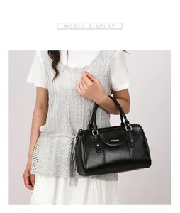 Elegant black retro Boston pillow handbag with luxury gold hardware details on model