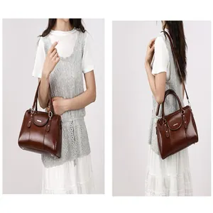 Detailed view of a retro brown oil leather Boston handbag shown with shoulder strap