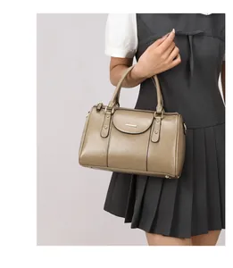 Model holding a vintage khaki oil leather Boston bag, highlighting the elegant retro style.