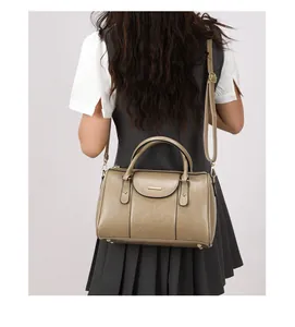 Back view of a woman wearing a vintage tan oil leather Boston crossbody handbag