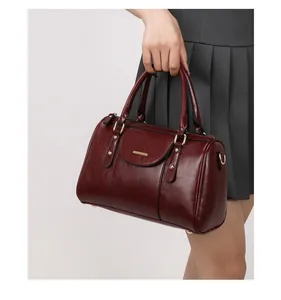 Detailed view of a model holding a vintage burgundy oil leather Boston handbag with gold accents