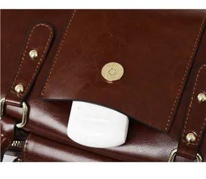 Macro view of vintage brown oil skin Boston bag featuring a magnetic snap closure detail