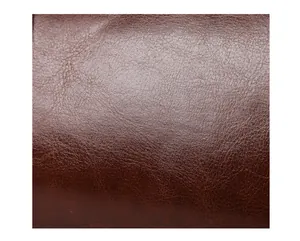 Detailed close-up macro shot showing the retro brown oil leather texture of a vintage handbag