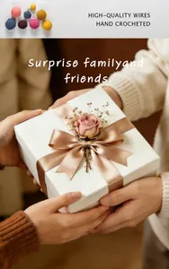Detailed view of a hand-crocheted rose flower decoration on a white gift box with silk ribbon