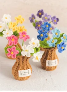 Detailed macro shot of handmade colorful crochet flowers in brown knitted pots