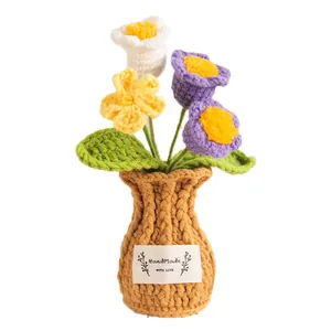 Hand-knitted colorful potted flowers in a crochet vase for cozy home tabletop decor