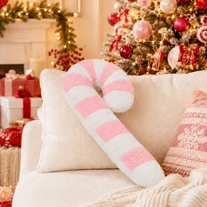Cojín de peluche con forma de bastón de caramelo a rayas rosas y blancas en sofá