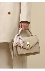 Elegante beige Handtasche mit dekorativem Seidenschal mit Herzmuster als Detail