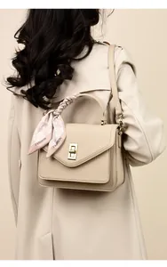 Elegante beige Lederhandtasche mit Seidenschal, von hinten an einem Model getragen.