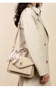 Detailaufnahme einer beigen minimalistischen Umhängetasche mit elegantem Seidentuch-Griff