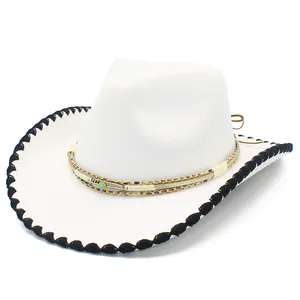 Détail d'un chapeau de cowboy blanc en laine avec bord surjeté noir et ruban à plumes orné.