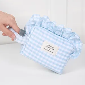 Aesthetic light blue gingham cosmetic bag with ruffle trim and portable handle for travel