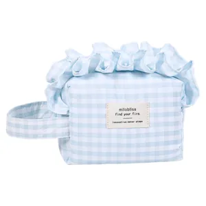 Fresh blue checkered handheld cosmetic bag with elegant ruffle trim and side strap.