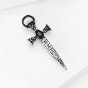 Vue détaillée macro d'une broche épée en argent vintage avec gemme noire et strass