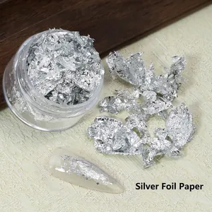Vue détaillée de flocons de feuilles d'argent pour nail art sur des ongles manucurés