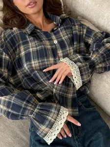 Detail of retro navy plaid shirt featuring delicate white lace-trimmed flared cuffs.