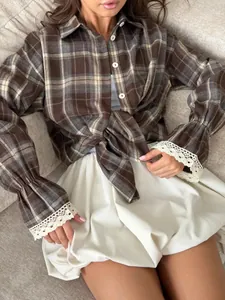 Detailed shot of a vintage brown plaid shirt featuring flared cuffs with white lace trim