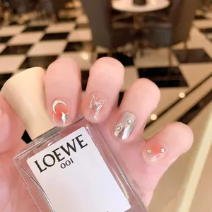 Handmade premium press-on nails featuring silver butterfly moon and star designs on peach