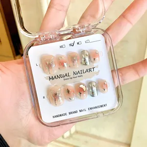 Handmade press-on nails with liquid butterfly and glitter design in a clear storage box