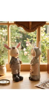 Figuras artísticas de pareja de conejos de resina estilo campestre en una ventana