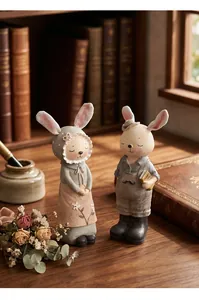 Par de lindas figuritas de conejos en un escritorio de madera con libros antiguos