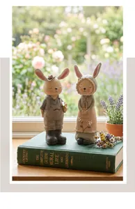 Primer plano de figuras de pareja de conejos estilo Zakka sobre un libro antiguo rústico
