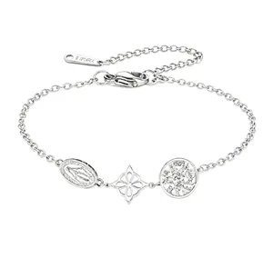 Détail d'un bracelet en acier inoxydable argenté avec breloques religieuses et florales