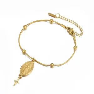 Détail d'un bracelet en acier inoxydable doré avec une médaille de la Vierge Marie et croix