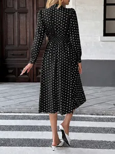 Vue arrière d'une robe midi élégante à pois noirs et blancs avec des manches longues