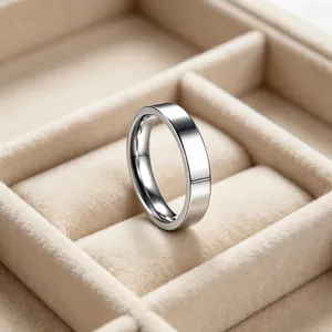 Close-up of a minimalist silver stainless steel band ring in a beige jewelry box