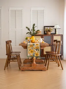 Runner da tavola floreale giallo con nappe verdi in una calda sala da pranzo vintage