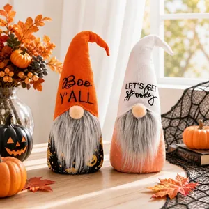 Close-up of two cute Halloween gnomes with festive embroidery on a wooden table