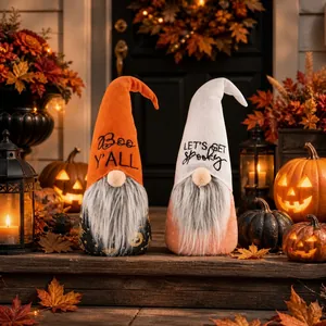 Close-up view of two cute Halloween gnome plush ornaments with festive themed hats.
