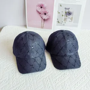 Vista detallada de dos gorras de béisbol de mezclilla azul con lentejuelas y rombos