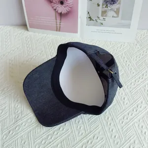 Detalle interior de gorra de béisbol de mezclilla oscura con correa trasera ajustable.