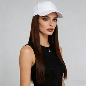 Close-up detail view of a white baseball cap with long straight brown hair on a model