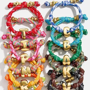 Handmade colorful braided rope bracelets featuring glossy gold 26 English letter charms.